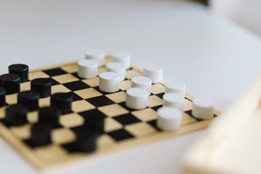 Teenage Girl and Boy Playing Board Game checkers In Living Room photo