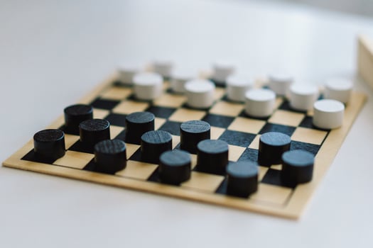 Teenage Girl and Boy Playing Board Game checkers In Living Room photo