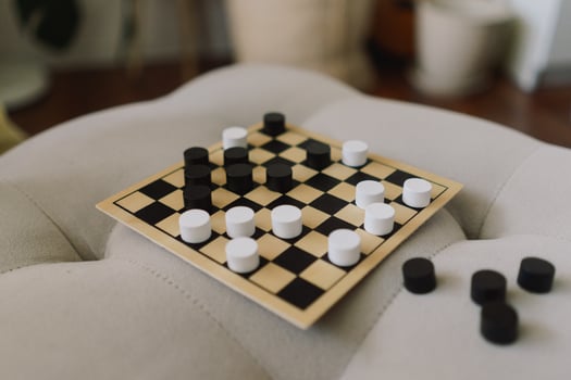 Teenage Girl and Boy Playing Board Game checkers In Living Room photo
