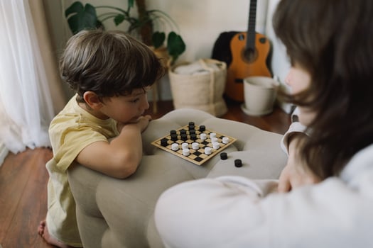 Teenage Girl and Boy Playing Board Game checkers In Living Room photo