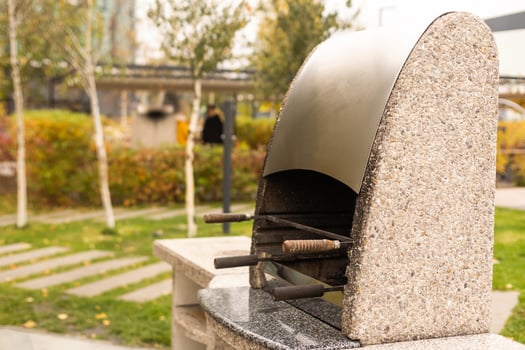 metal barbecue set with firewood and roof stands in a small park. Autumn landscape with barbecue area photo