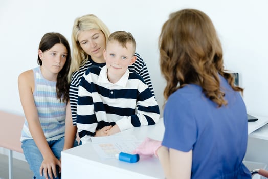 A mother with her son and daughter at a doctor's consultation in a clinic photo