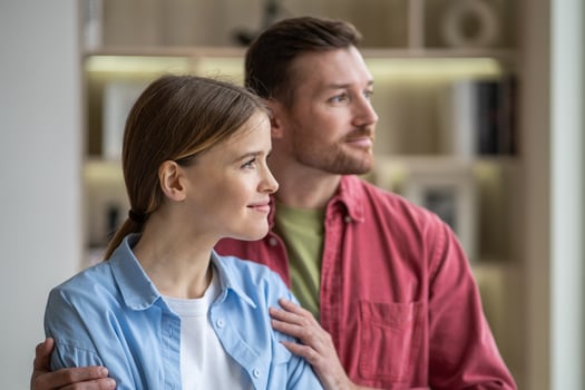 Happy calm romantic couple embracing and looking window in cozy apartment. Comfort marriage, love photo