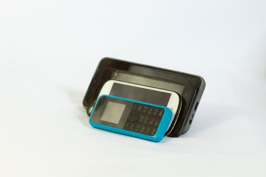 several phones tilted and photographed close up from a side angle with an isolated background photo