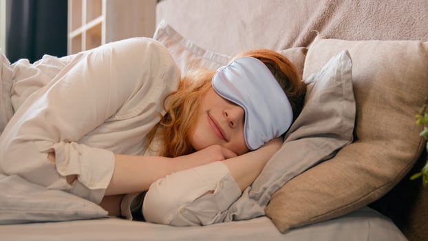 Sleepy beautiful woman waking up lying in comfortable white bed peeks out from under sleep mask opens eye happy smile fall asleep again girl female early good morning napping in cozy bedroom lazy lady photo