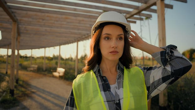 Experienced Caucasian woman female girl businesswoman in hardhat workwear observing inspecting building check ecology business ecological engineer inspector stroll architect walking rural meadow field photo