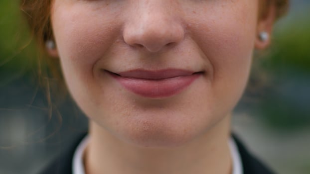 Close up beautiful perfect smile mouth lips young unrecognizable successful Caucasian female lady woman businesswoman smiling charmingly outdoors urban city street. Emotions feelings business victory photo