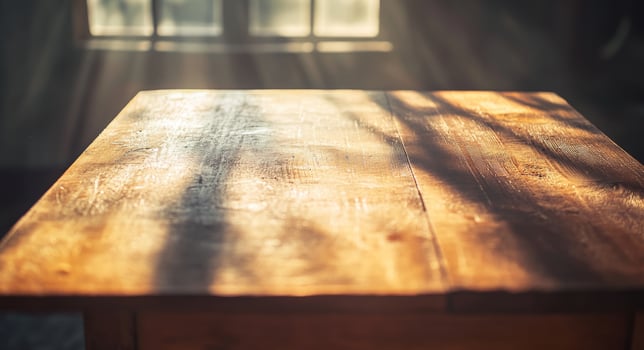 Sunlight illuminating a rustic wooden table in a cozy indoor setting during the late afternoon photo