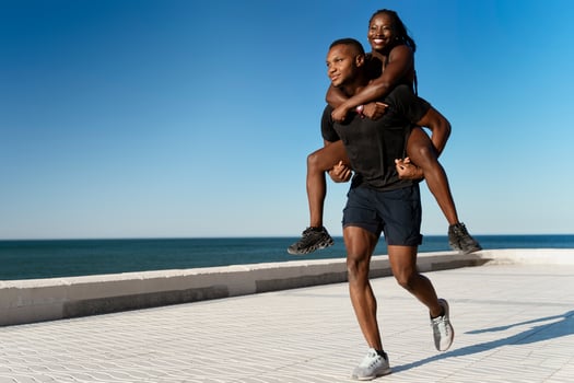 Young multiracial woman piggybacking on male boyfriend outside photo