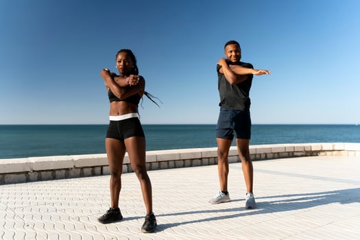 Multiracial couple sportswoman sportsman in sport clothes warming up and training photo