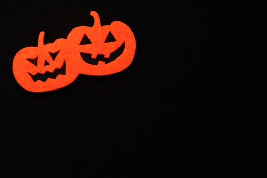 felt orange halloween pumpkin on a black background. dark background for halloween photo
