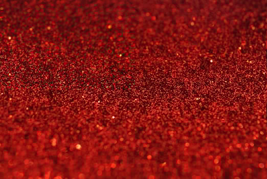 Close-up of Defocused Golden Glitter Sparkles on Red Background photo