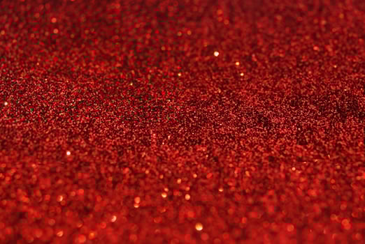 Close-up of Defocused Golden Glitter Sparkles on Red Background photo