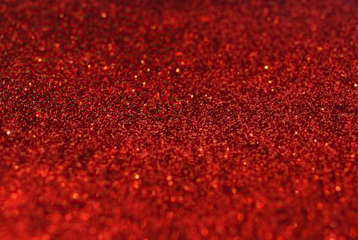 Close-up of Defocused Golden Glitter Sparkles on Red Background photo