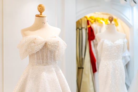 Beautiful wedding dresses, bridal dress hanging on hangers and mannequin in studio. Fashion look. photo