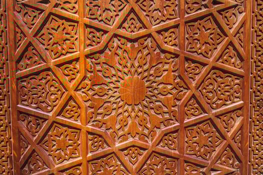 asian Uzbek patterns ornament on wooden carved door in Uzbekistan close-up photo