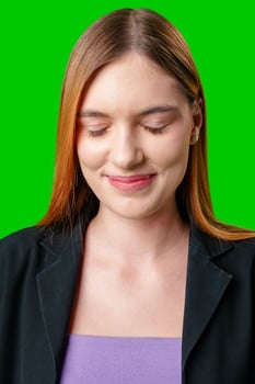 Young Woman Smiling With Eyes Closed in Front of Green Screen photo