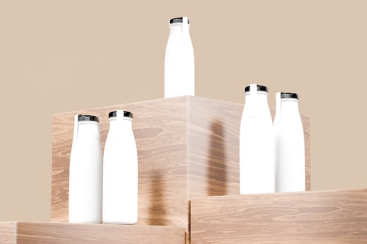 White isolated milk bottles with black caps and label paper, beige background with 3D rendering to show the product photo