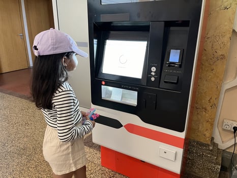 Asian little girl in front of the ticket machine printing tickets photo