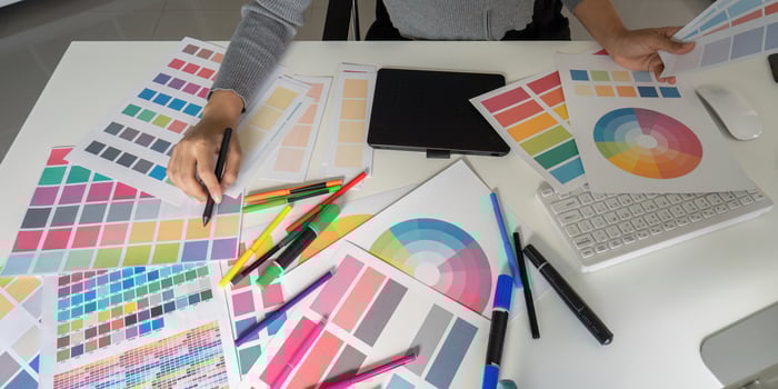 Graphic designer organizing color swatches on desk photo