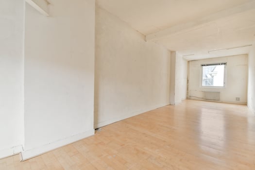 An empty room with a wooden floor and white walls photo
