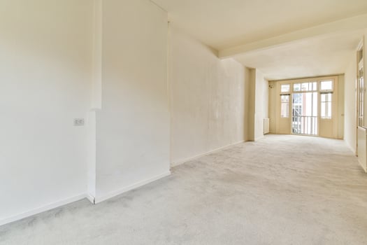 A long hallway with white walls and a door photo