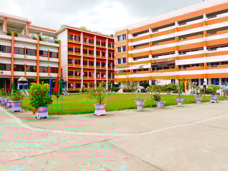 Big Orange and White School Structure with Abundant Parking and Open Yard photo