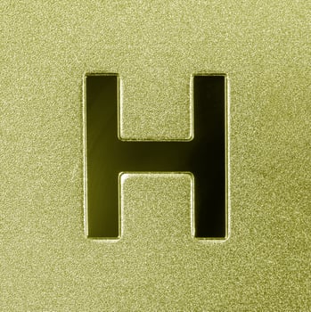 Letter H on a golden grained shiny metal surface. English alphabet. photo