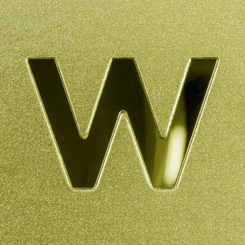 Letter W on a golden grained shiny metal surface. English alphabet. photo