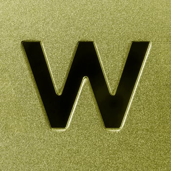 Letter W on a golden grained shiny metal surface. English alphabet. photo