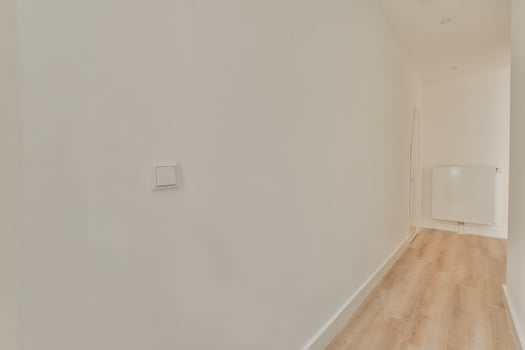 A hallway with white walls and wooden floors photo