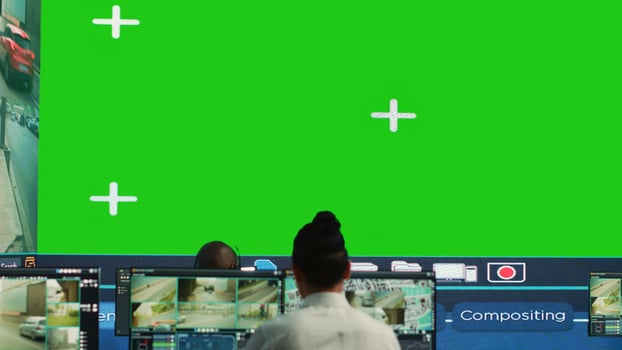 Courier agency operators monitoring cargo shipment with a greenscreen, working in observation room. Employees give directions to truck drivers stuck in traffic, CCTV system. Camera A. photo