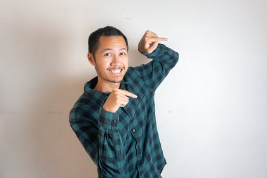 Young Adult Asian men pointing finger to the right with smiling face and exited expression with isolated white background photo