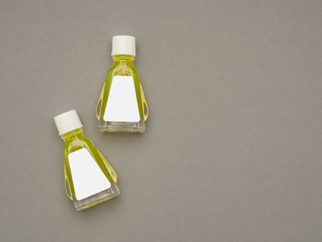 Small bottle containers with yellow herbal. Blank label for branding mockup. Natural beauty and health product concept photo