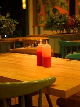 Sauce and mustared bottles at restaurant table photo