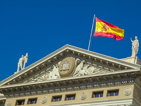 A spanish flag flying on top of a building photo