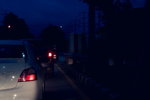Blurred image rear sie view of cars on the road with turn on brake light at night. Environment of car at night with guard lens on the road. photo
