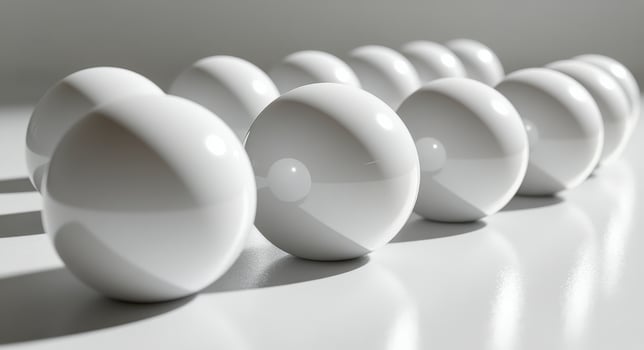 Bright sunlight illuminates white spheres on a wooden table creating delicate shadows photo
