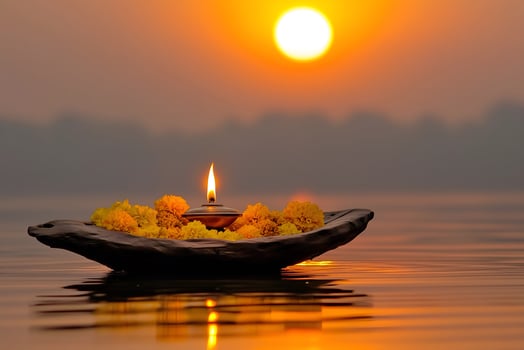 An oil lamp surrounded by marigold flowers floating in the river, during Pitru Paksha photo