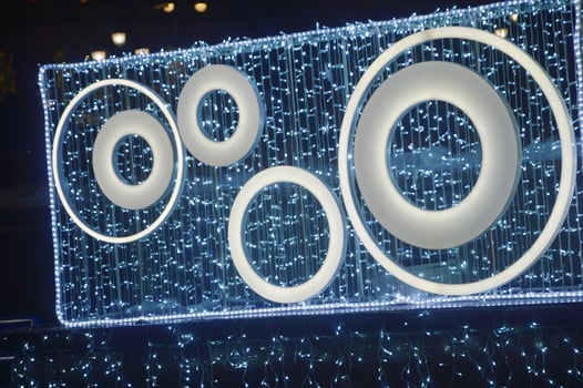 Element of festive Christmas lighting. Decorative panel with silver glowing circles against the night sky. New Year's city street decor. photo