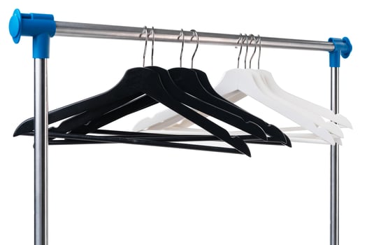 Metal rack with clothes hangers on white background photo