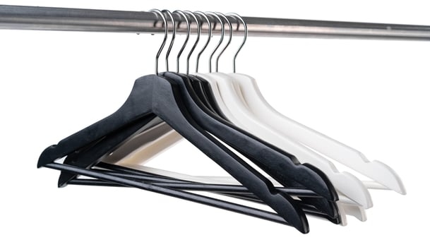 Metal rack with clothes hangers on white background photo