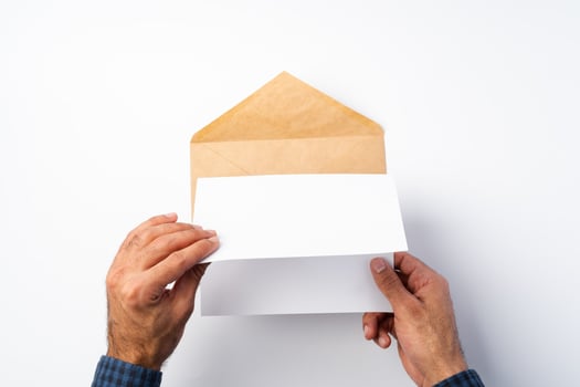 Top view of male hands hold , open an envelope above white background photo