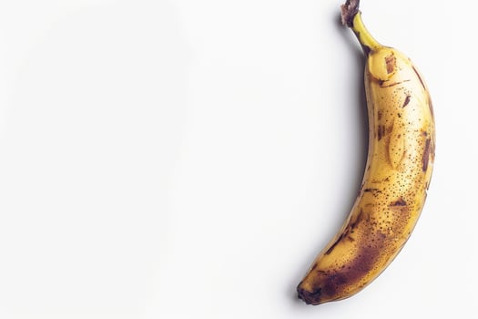A banana is shown on a white surface photo