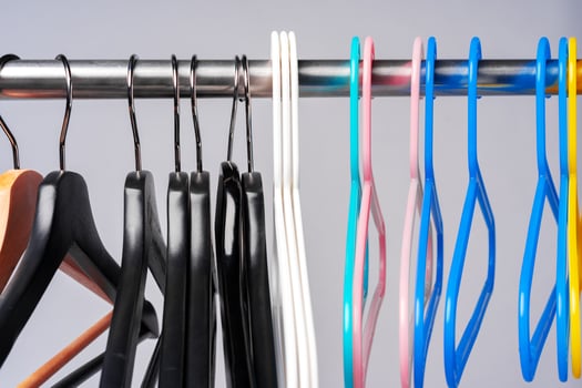 Metal rack with clothes hangers on grey background photo