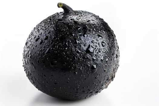 A black avocado with water droplets on it photo