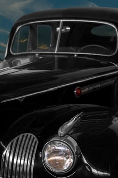 Vintage, black, shiny car against the background of the night sky. photo