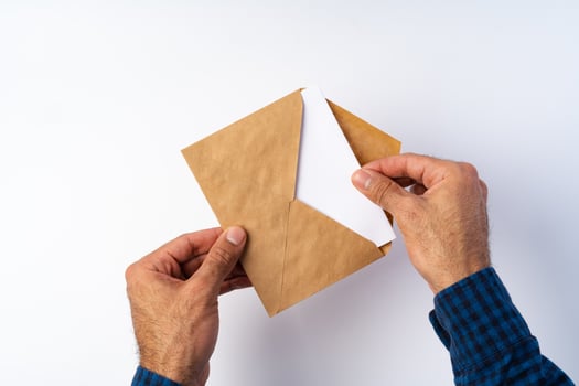 Top view of male hands hold , open an envelope above white background photo