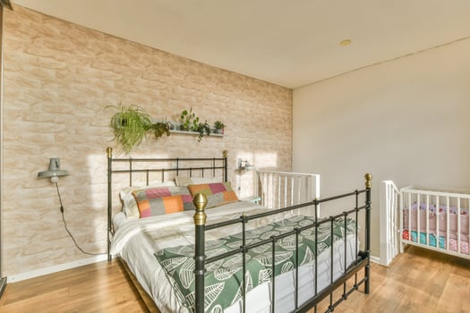 A bedroom with a bed and a crib photo