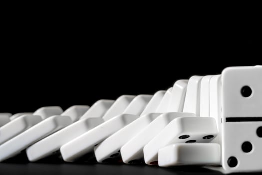Dominoes standing in a row on black background photo